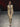 Look 20 desfile Un Romance Bien Latino 2026: enterizo entallado de cuello alto con capucha y mangas largas en estampado snake print arena y negro, zapatillas negras de tacón en punta y lentes de sol carey.